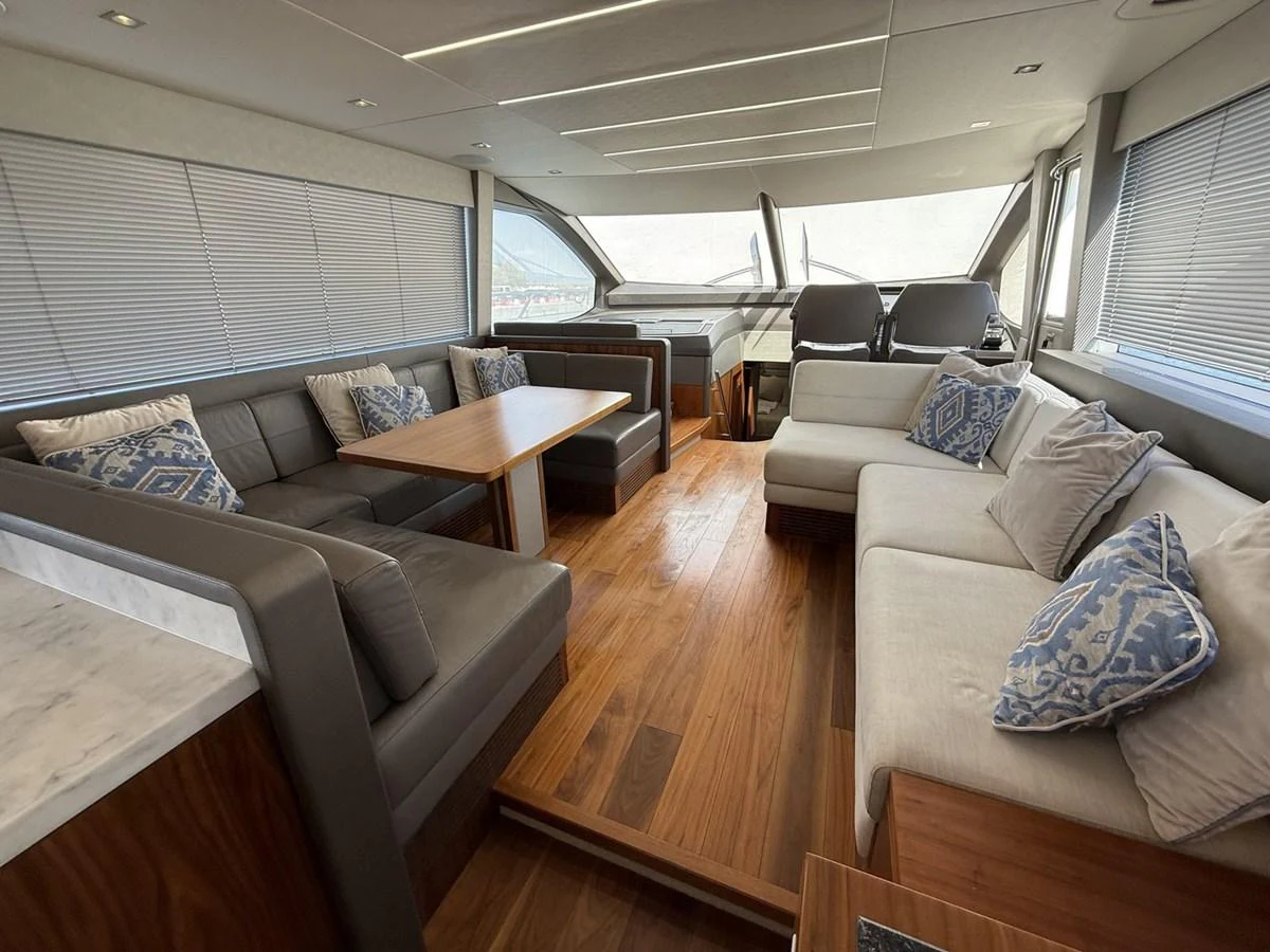 The salon features elegant seating with plush cushions and a stylish wooden table, creating a cozy and inviting atmosphere. aboard "BISHWISH" Yacht for Sale