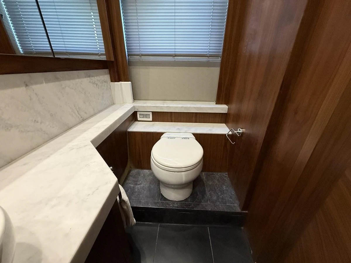 A well-appointed yacht bathroom features elegant wood paneling and a marble countertop. aboard "BISHWISH" Yacht for Sale