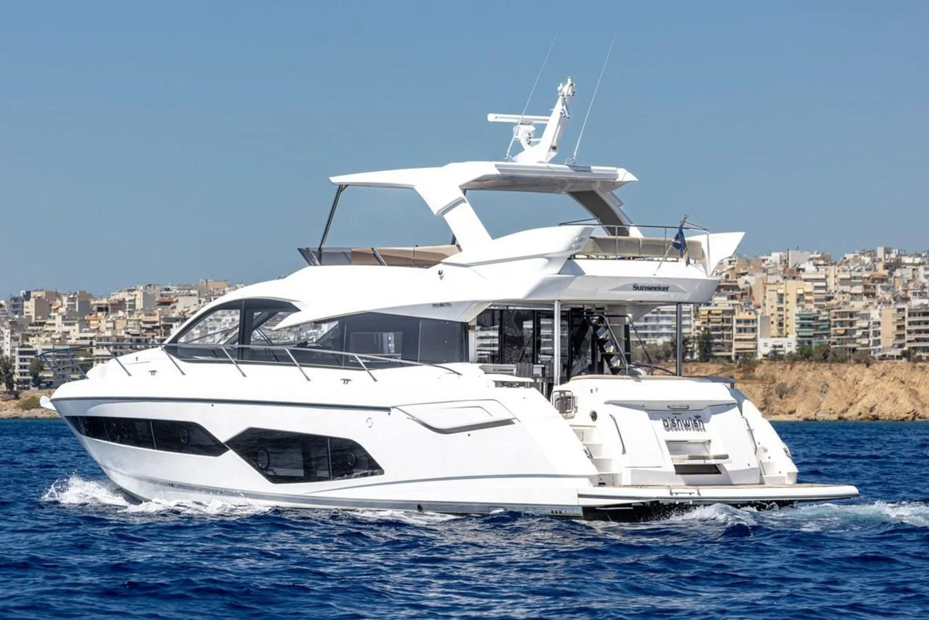 A sleek and modern yacht cruises on the open water with a cityscape in the background. aboard "BISHWISH" Yacht for Sale