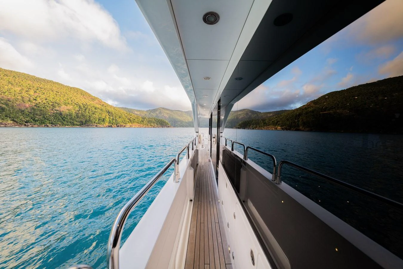The side deck offers a serene view of the surrounding waters and lush hills. aboard RASCAL Yacht for Sale