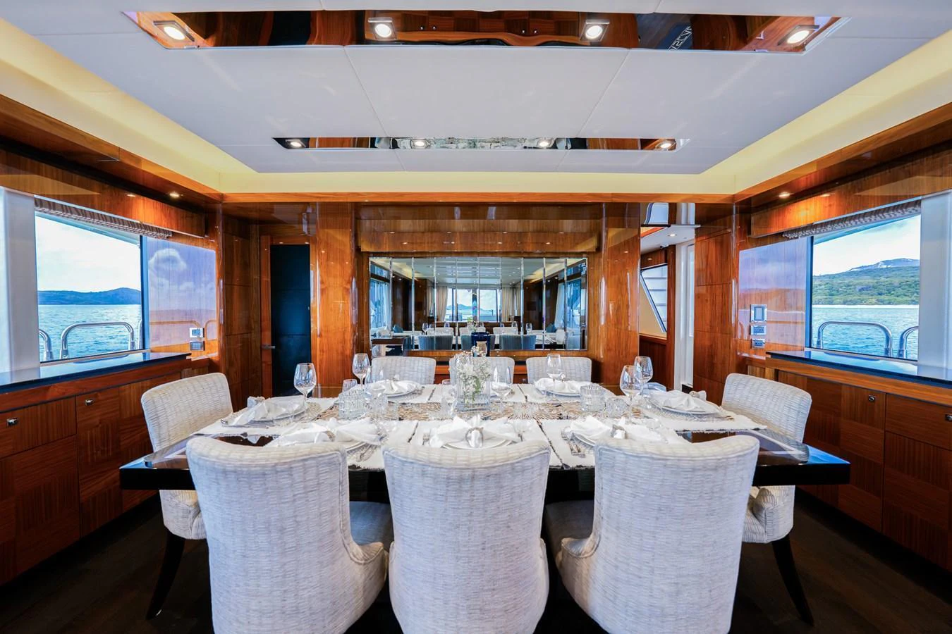 The yacht's dining area features a luxurious table setting with plush seating and panoramic views. aboard RASCAL Yacht for Sale