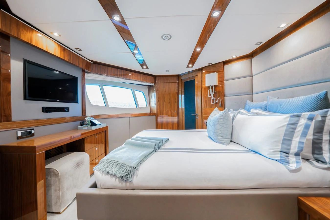 The stateroom features luxurious bedding, elegant wood finishes, and ample natural light. aboard RASCAL Yacht for Sale
