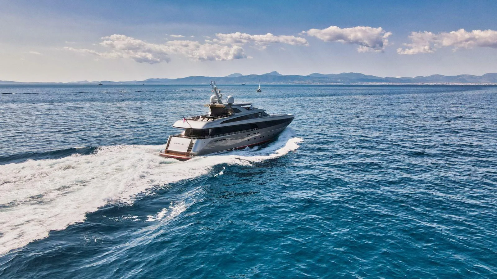 A sleek yacht cruises through the open sea under a clear blue sky. aboard SMOOTH OPERATOR Yacht for Sale