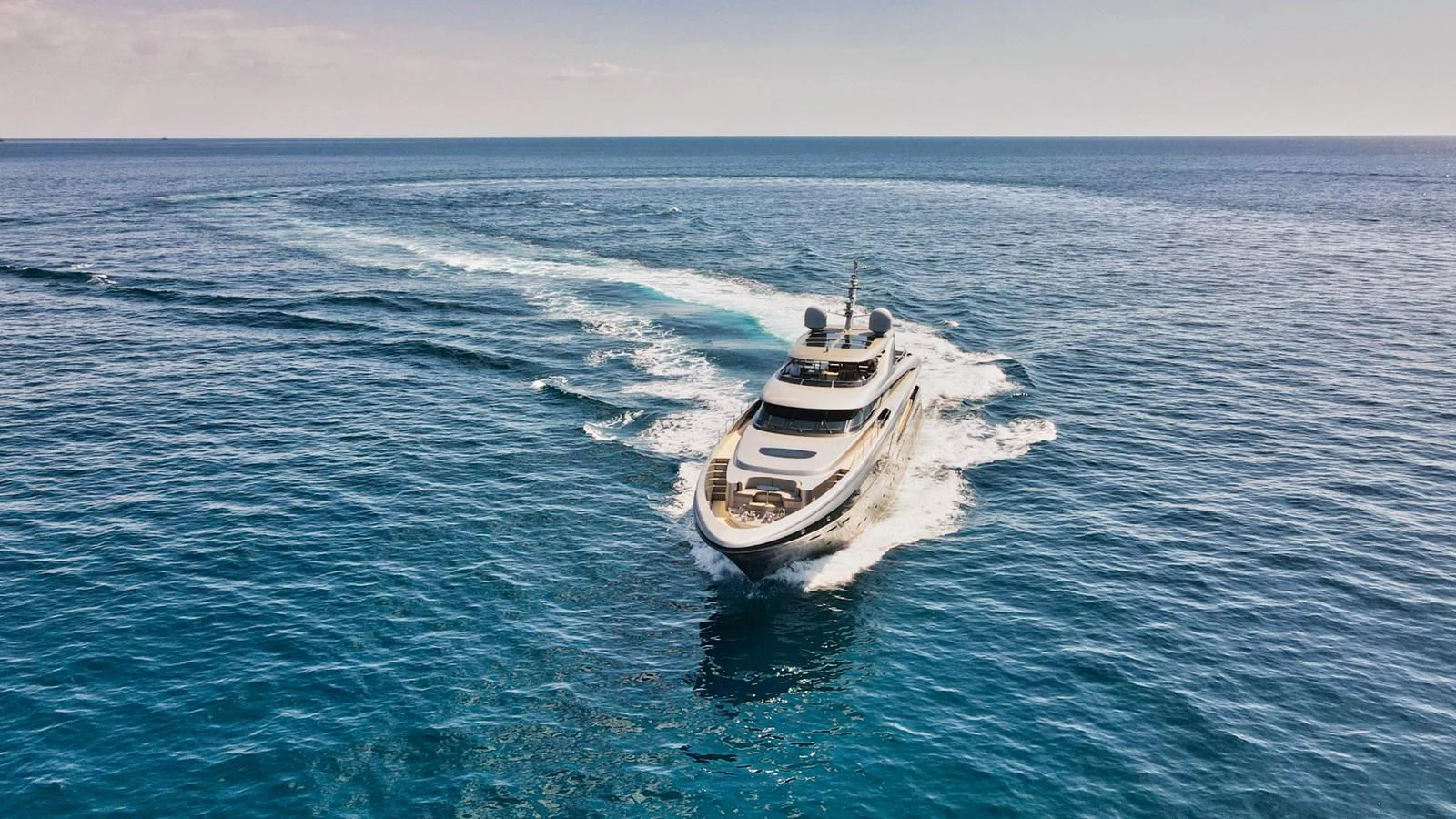 A luxurious yacht cruises through the open sea, leaving a trail of white wake behind. aboard SMOOTH OPERATOR Yacht for Sale