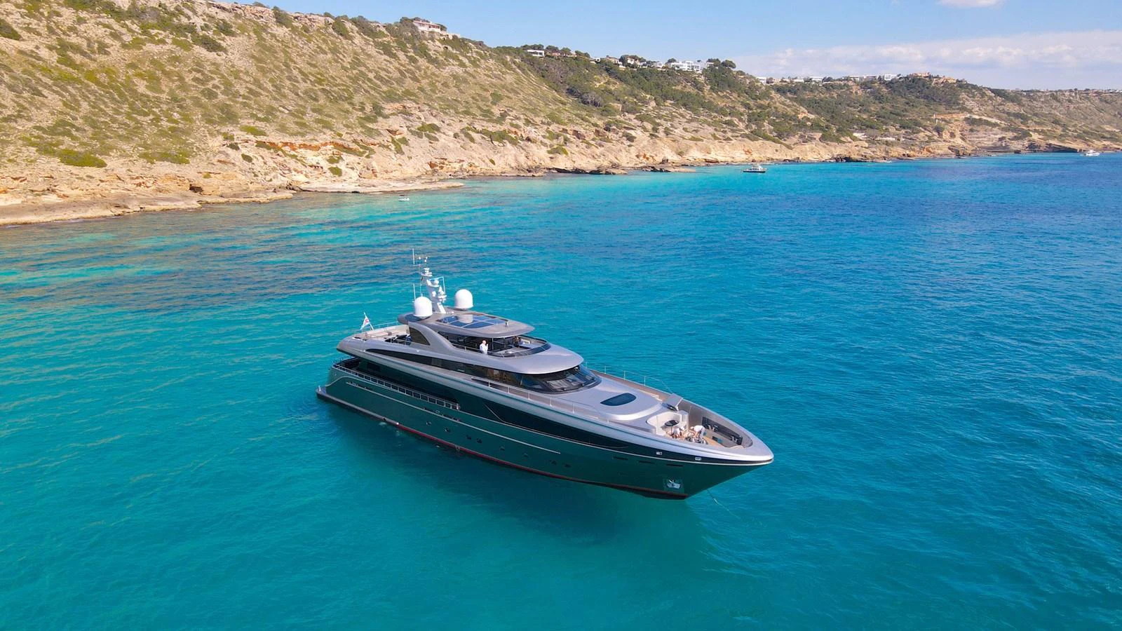 A sleek and modern yacht cruises along a stunning coastal landscape with crystal-clear waters. aboard SMOOTH OPERATOR Yacht for Sale