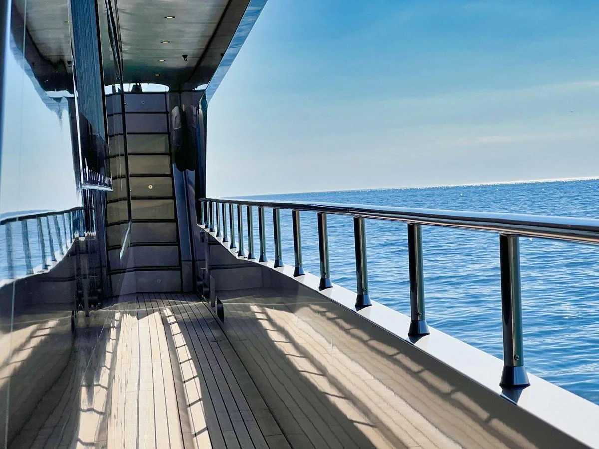 The sleek side deck of the yacht offers a serene view of the open sea. aboard SMOOTH OPERATOR Yacht for Sale