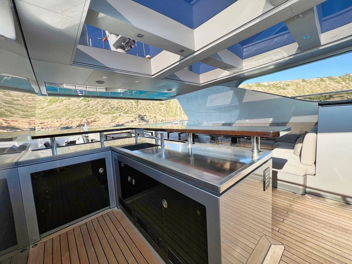 The yacht's aft deck features a spacious and modern outdoor bar area with ample seating and stunning views. aboard SMOOTH OPERATOR Yacht for Sale