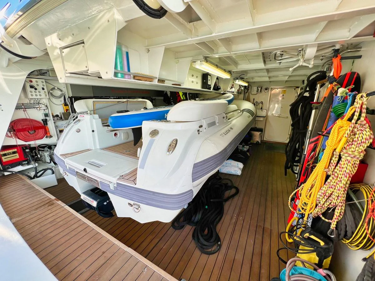 The image showcases a well-organized tender garage with a neatly stored tender boat and various equipment. aboard SMOOTH OPERATOR Yacht for Sale