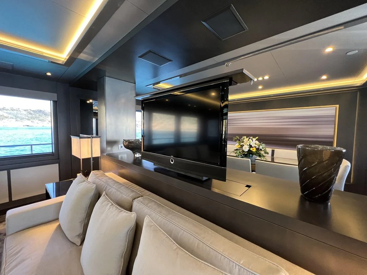 The yacht's interior features a modern living area with a large flat-screen TV and comfortable seating. aboard SMOOTH OPERATOR Yacht for Sale
