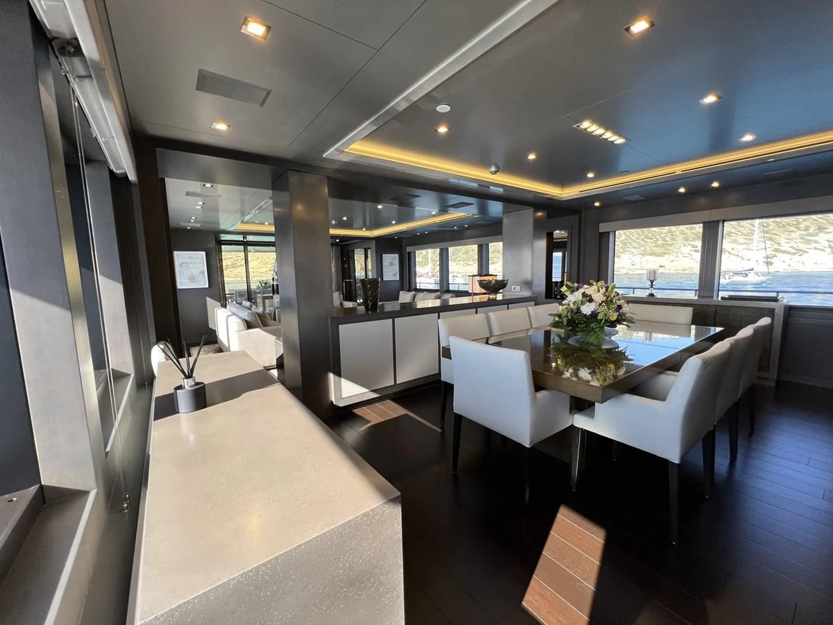 The yacht's dining area features a modern, elegant design with ample natural light and luxurious furnishings. aboard SMOOTH OPERATOR Yacht for Sale