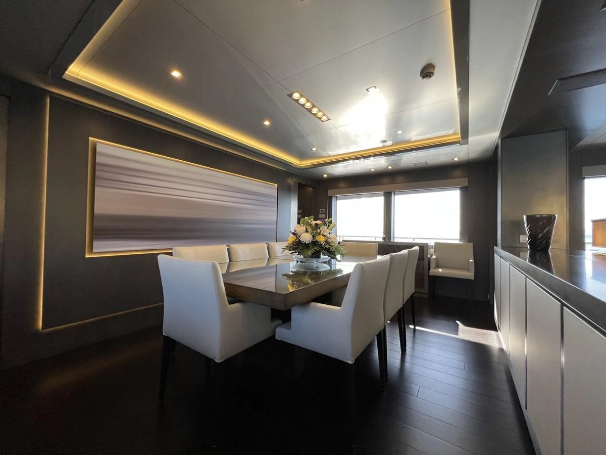 The yacht's dining area features a modern table with elegant seating and ambient lighting. aboard SMOOTH OPERATOR Yacht for Sale