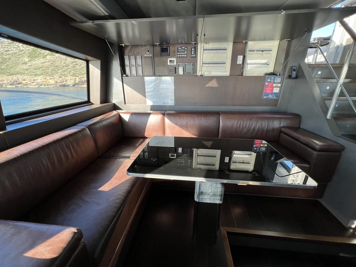 The saloon features a sleek, modern design with a comfortable leather seating area and a polished table. aboard SMOOTH OPERATOR Yacht for Sale