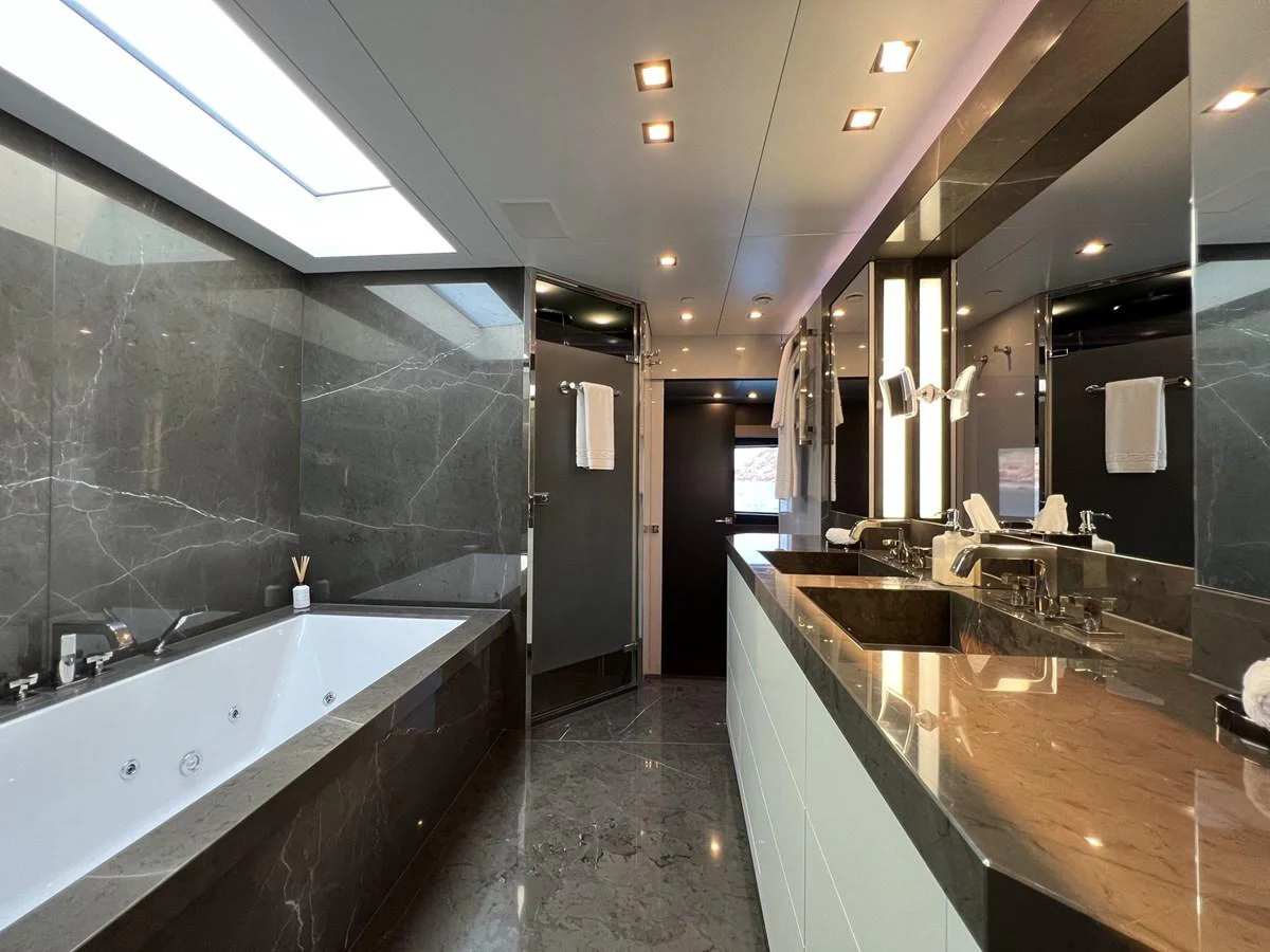 The luxurious bathroom features a spacious bathtub and elegant marble finishes. aboard SMOOTH OPERATOR Yacht for Sale