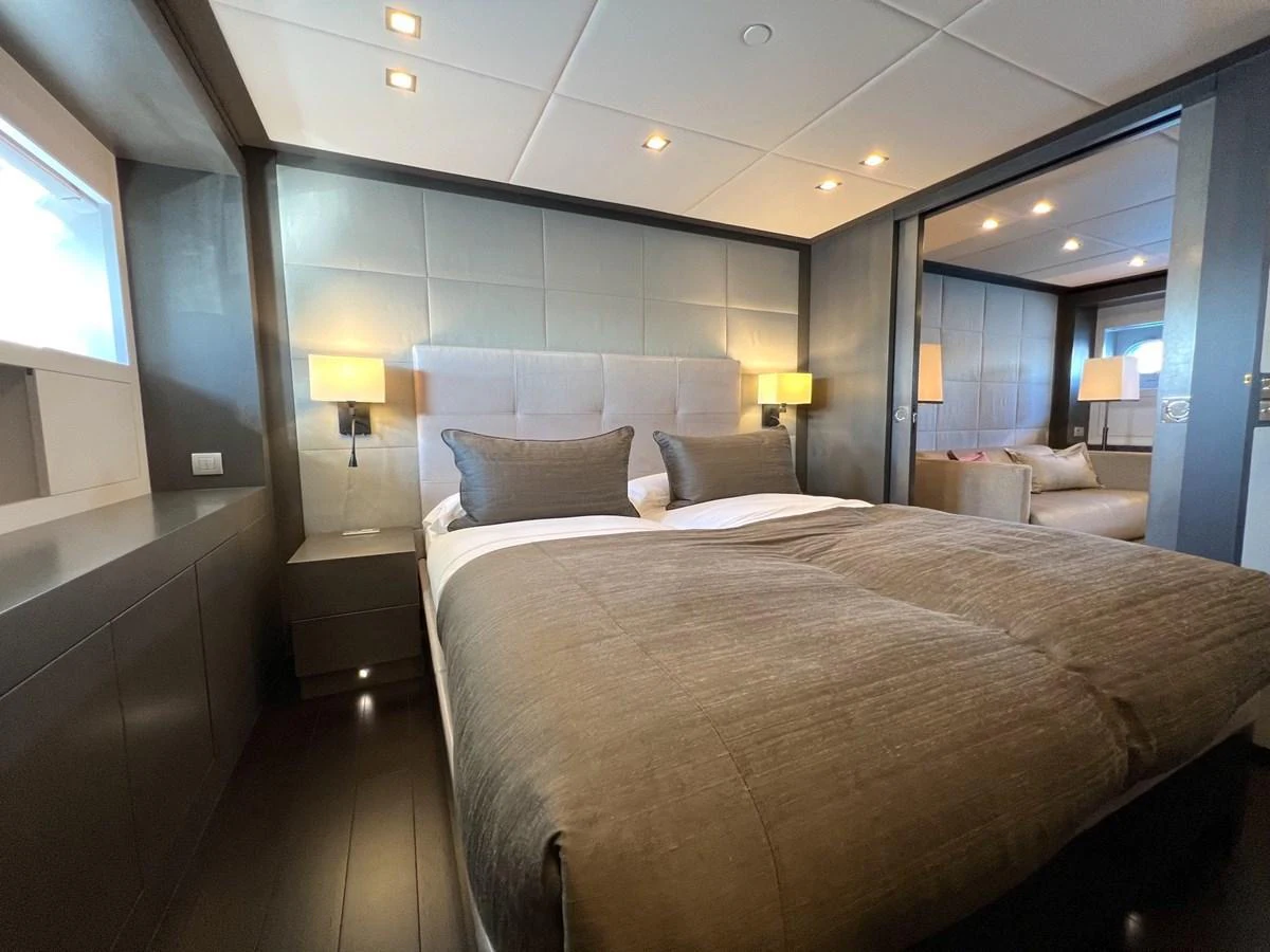 A luxurious stateroom featuring a plush bed with elegant bedding and ambient lighting. aboard SMOOTH OPERATOR Yacht for Sale