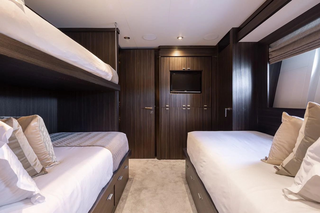 The guest stateroom features cozy twin beds with elegant wood paneling and a wall-mounted TV. aboard BAGHEERA Yacht for Sale