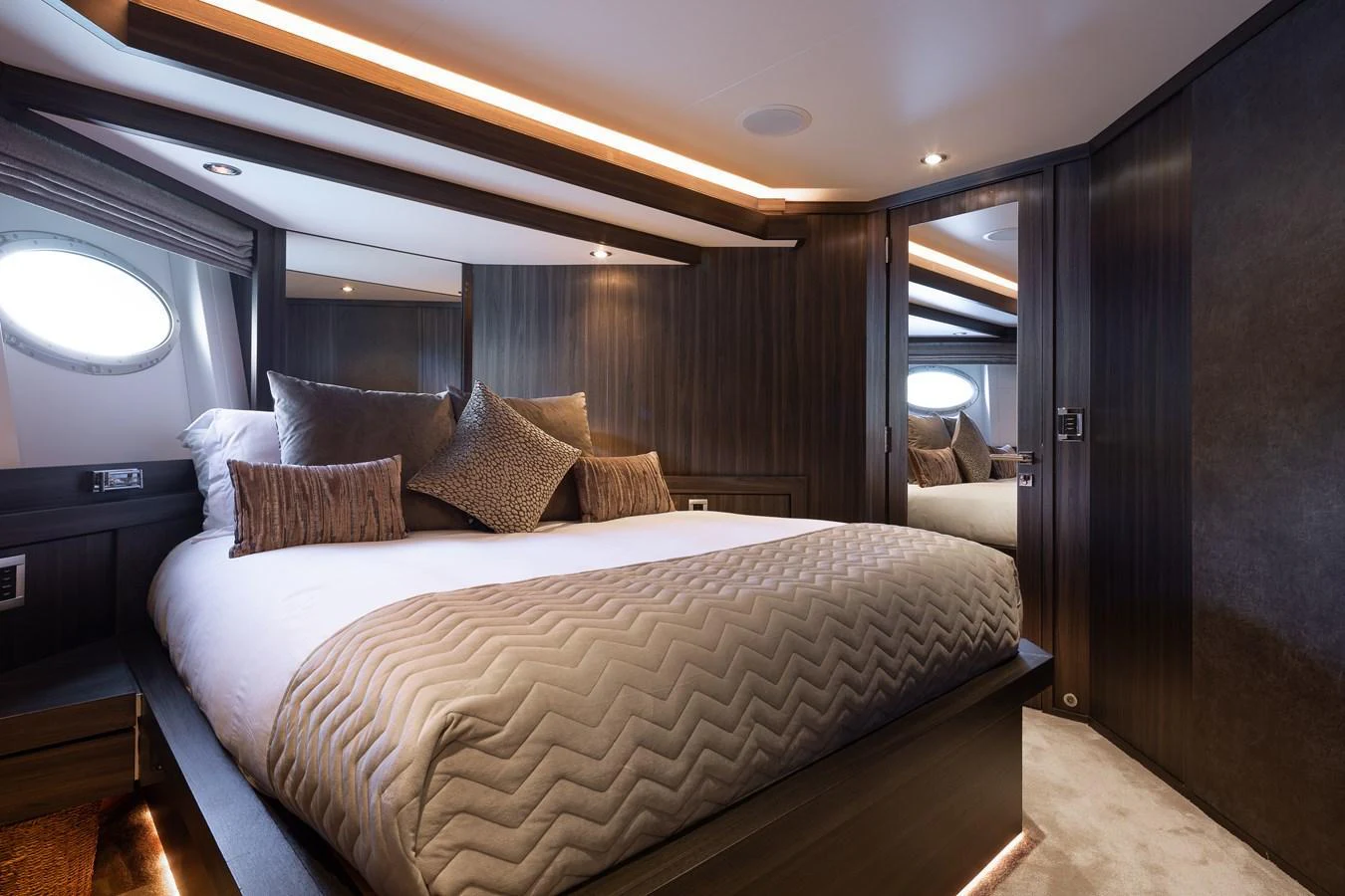 The stateroom features a luxurious bed with elegant bedding and ambient lighting. aboard BAGHEERA Yacht for Sale
