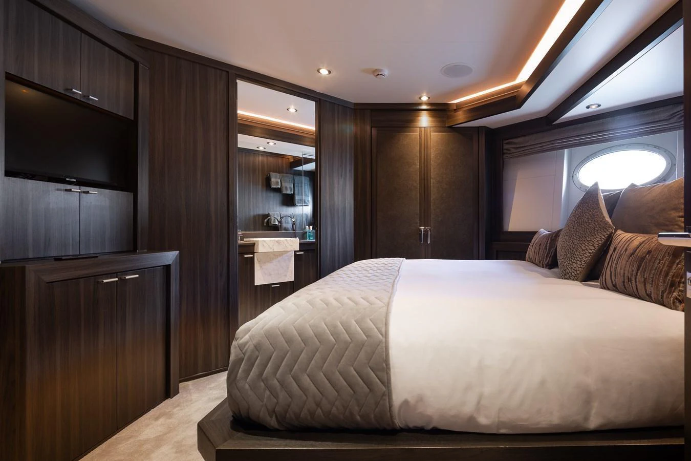 The stateroom features a luxurious bed with elegant bedding and modern wooden cabinetry. aboard BAGHEERA Yacht for Sale