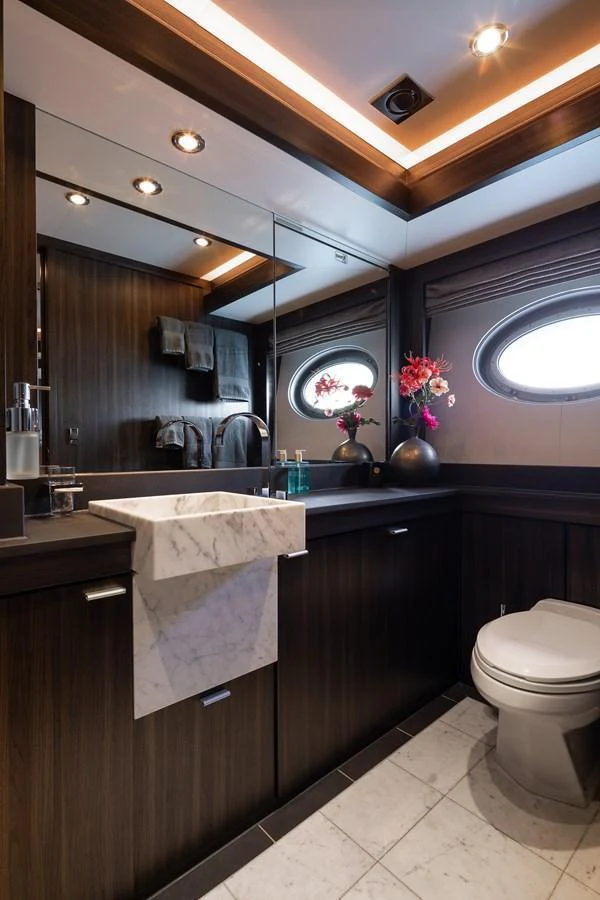 A luxurious yacht bathroom featuring elegant wood paneling and a marble sink. aboard BAGHEERA Yacht for Sale