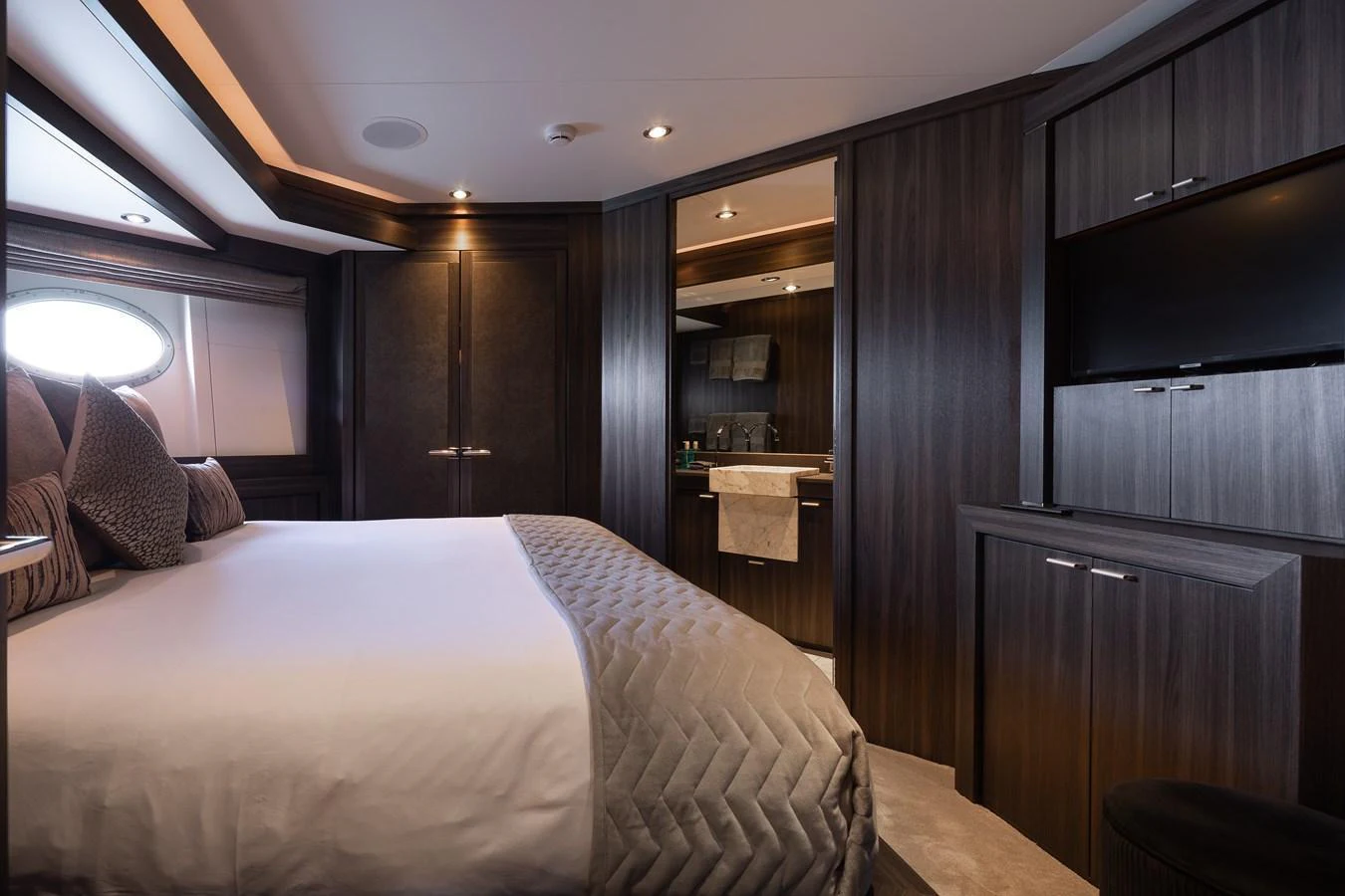 The stateroom features a plush bed with elegant bedding and modern wood finishes. aboard BAGHEERA Yacht for Sale
