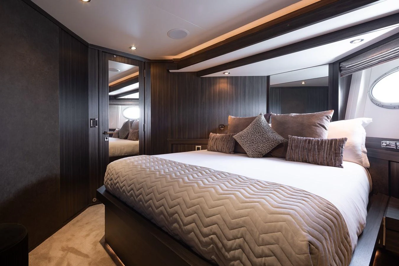 The stateroom features a luxurious bed with plush pillows and elegant wood paneling. aboard BAGHEERA Yacht for Sale
