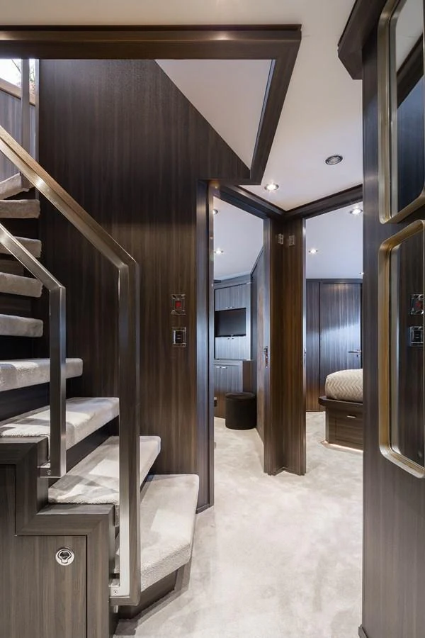 The yacht's interior features a modern staircase and hallway with luxurious finishes. aboard BAGHEERA Yacht for Sale