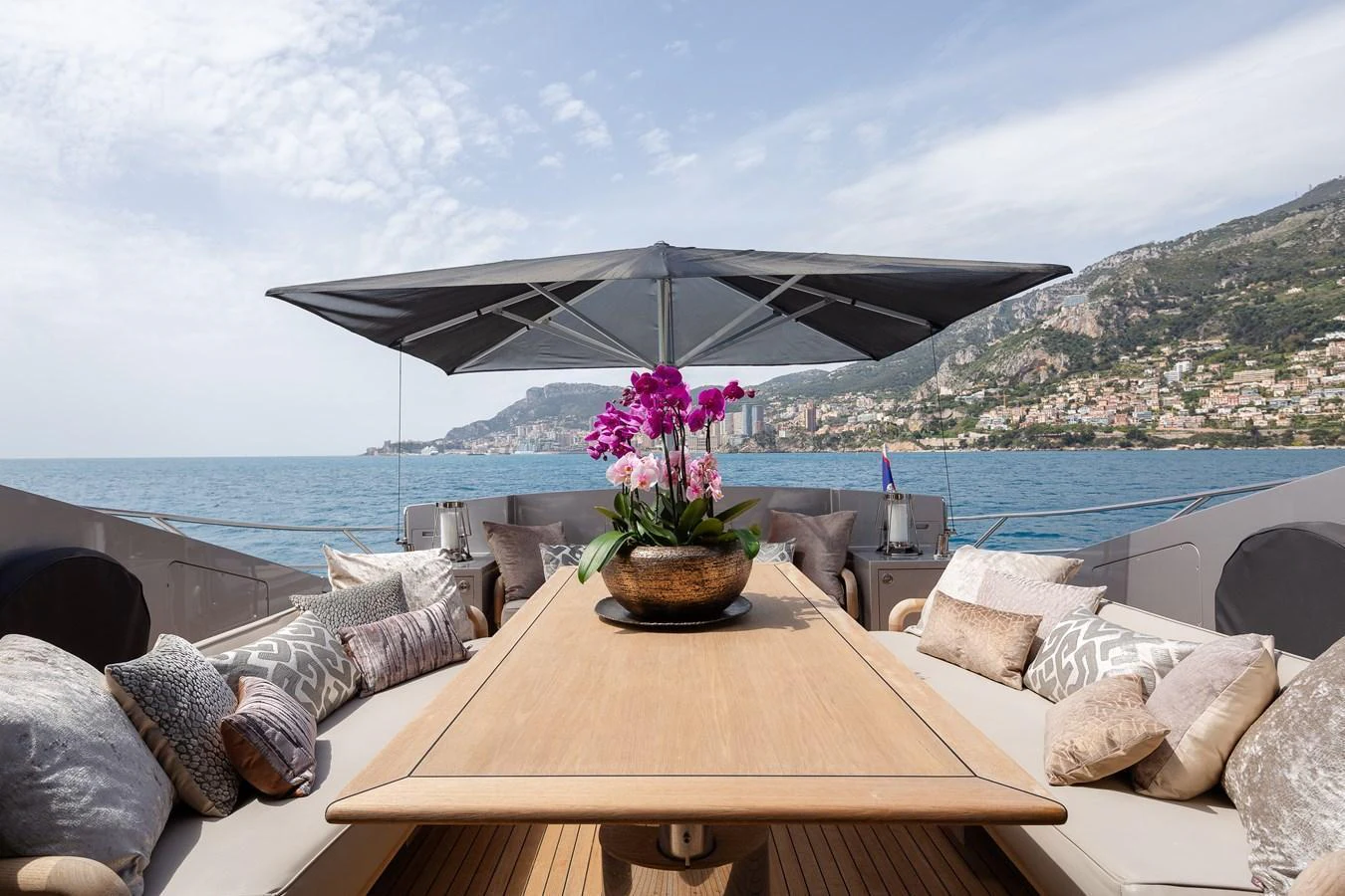 The aft deck features a spacious dining area with plush seating and a large parasol, perfect for alfresco dining with stunning sea views. aboard BAGHEERA Yacht for Sale
