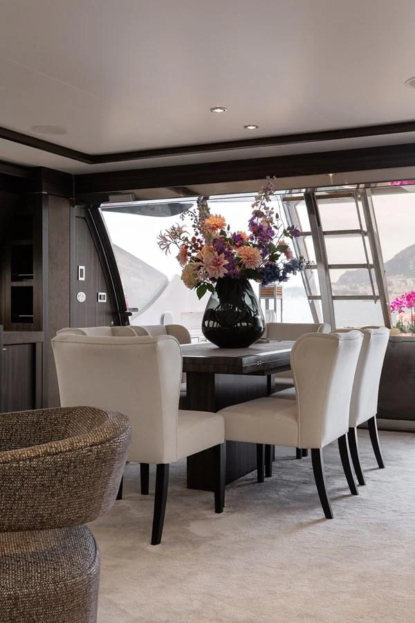 The yacht's dining area features elegant seating and a beautiful floral centerpiece, creating a luxurious and inviting atmosphere. aboard BAGHEERA Yacht for Sale