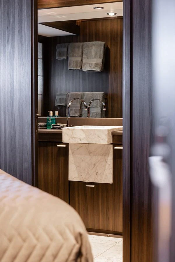 A luxurious bathroom with a marble sink and elegant wooden finishes. aboard BAGHEERA Yacht for Sale