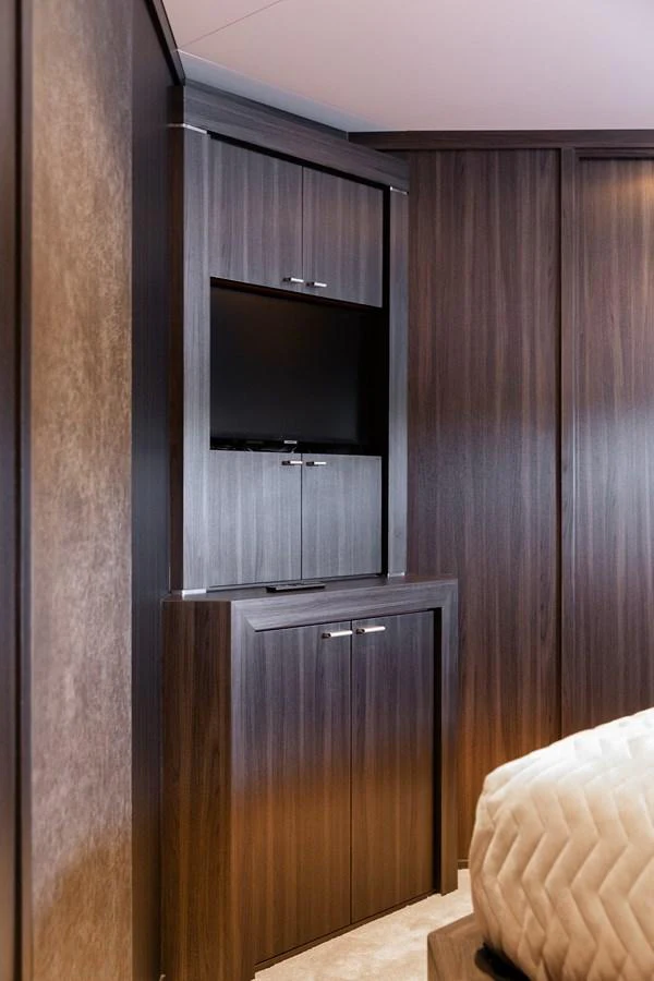 A luxurious stateroom featuring elegant wood cabinetry and a mounted television. aboard BAGHEERA Yacht for Sale
