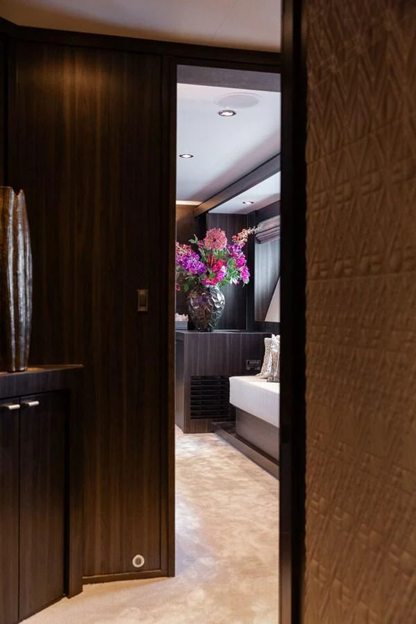 A luxurious stateroom with elegant wood finishes and a beautiful floral arrangement. aboard BAGHEERA Yacht for Sale