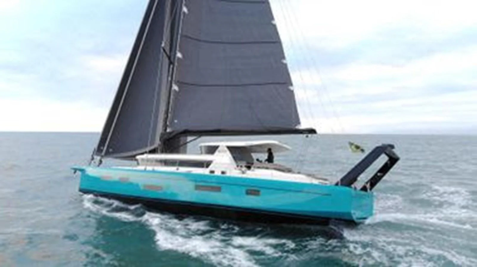 A sleek sailing yacht with a turquoise hull and black sails glides gracefully on the open sea. aboard 2025 MCP GLOBAL EXP 68 Yacht for Sale