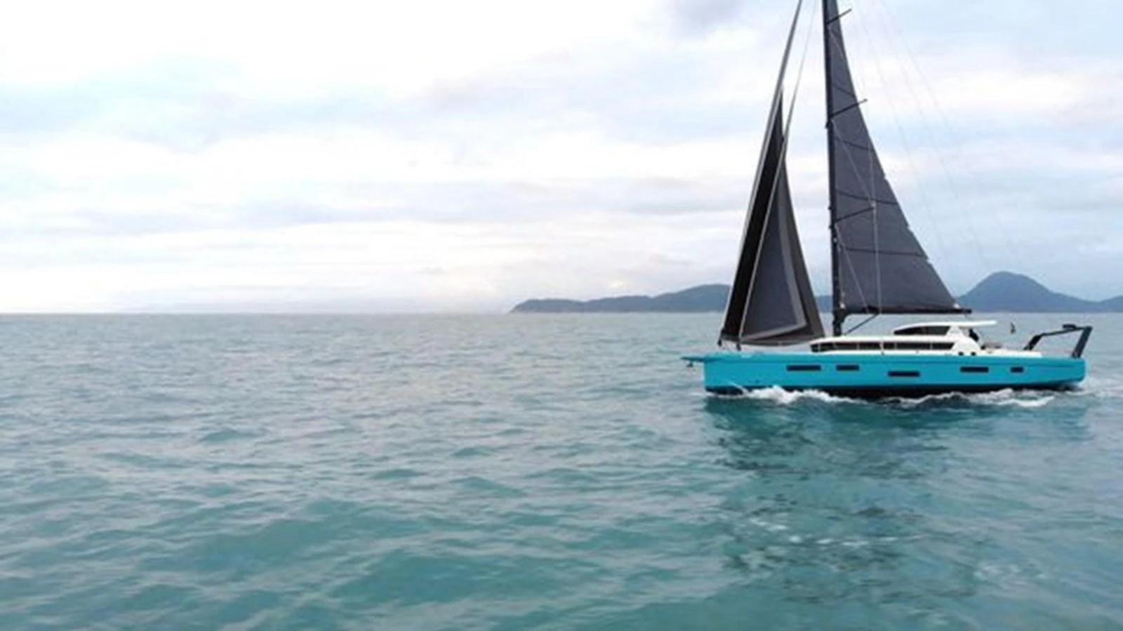 A sleek yacht with black sails glides gracefully over calm waters against a serene backdrop. aboard 2025 MCP GLOBAL EXP 68 Yacht for Sale