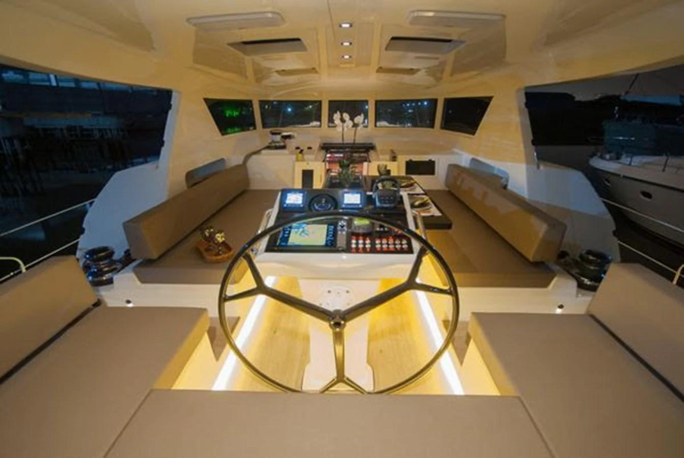 The helm station features modern navigation equipment and comfortable seating, illuminated by soft ambient lighting. aboard 2025 MCP GLOBAL EXP 68 Yacht for Sale