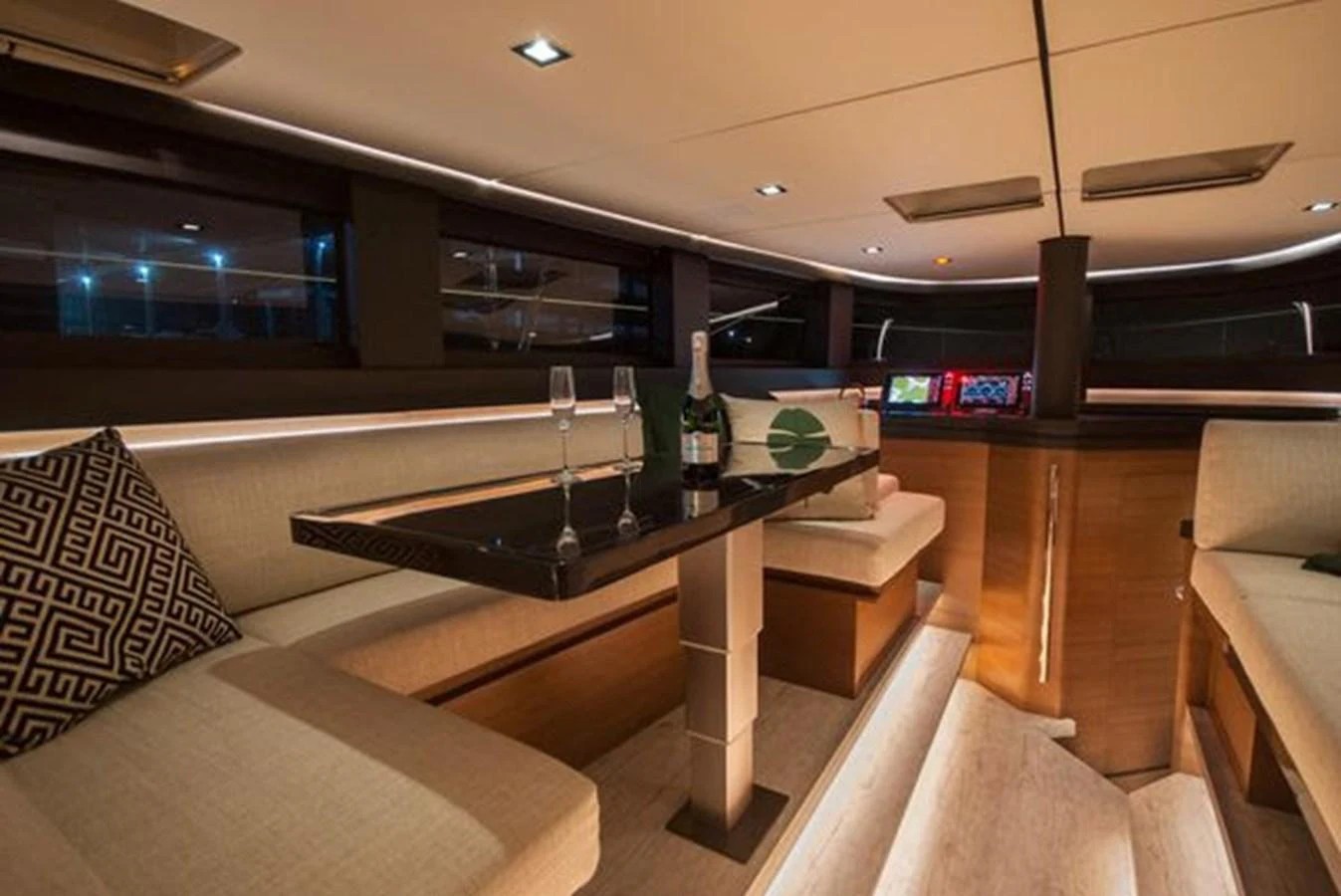 The yacht's salon features elegant seating with a central table and ambient lighting. aboard 2025 MCP GLOBAL EXP 68 Yacht for Sale