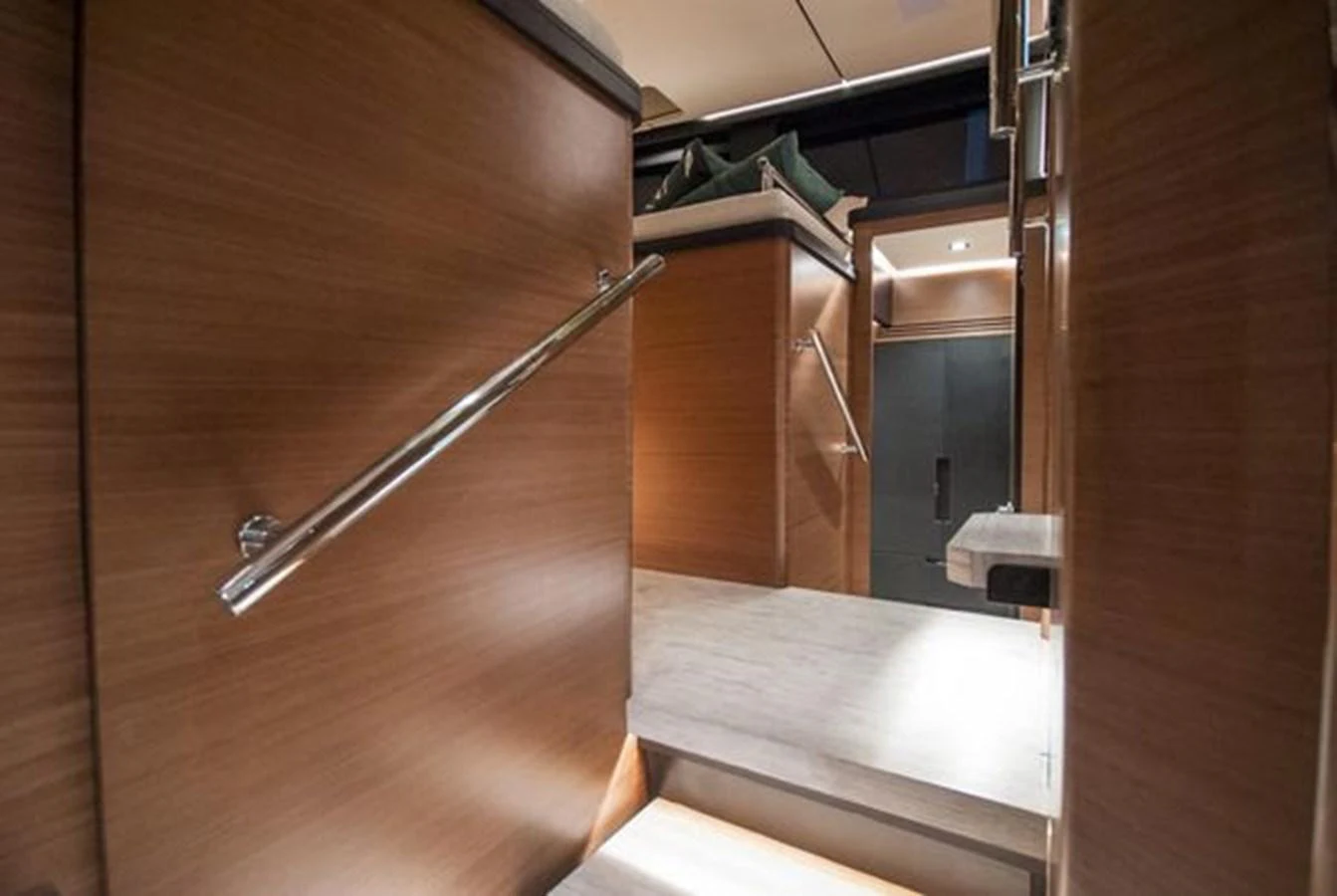 The yacht's interior features a modern hallway with wooden paneling and sleek metal handrails. aboard 2025 MCP GLOBAL EXP 68 Yacht for Sale