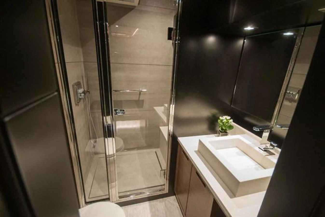 The yacht's bathroom features a modern design with sleek fixtures and a glass-enclosed shower. aboard 2025 MCP GLOBAL EXP 68 Yacht for Sale
