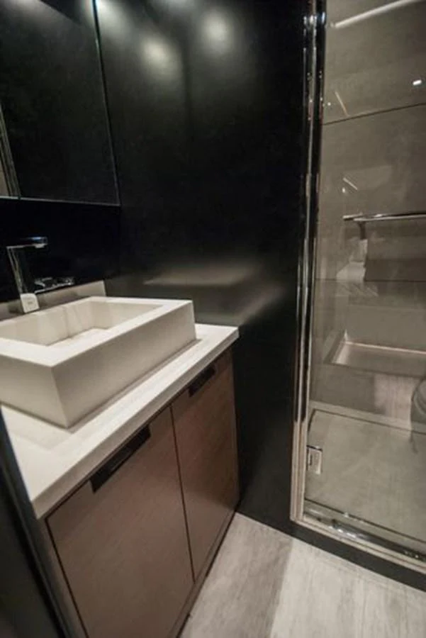 A sleek and modern bathroom with a glass-enclosed shower and a stylish sink. aboard 2025 MCP GLOBAL EXP 68 Yacht for Sale