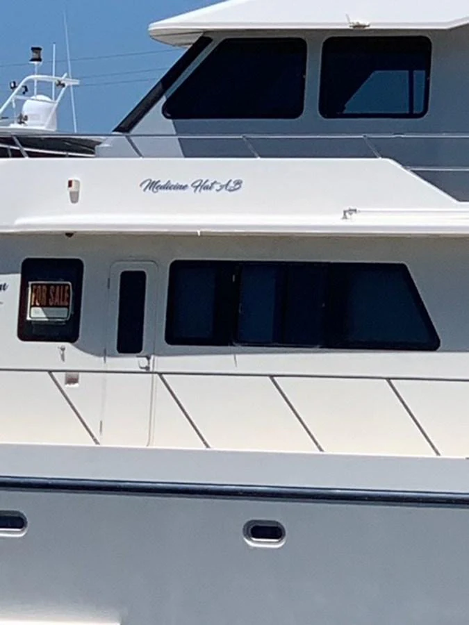 A close-up view of the yacht's exterior, showcasing its sleek design and large windows. aboard THE CAT FROM THE HAT Yacht for Sale