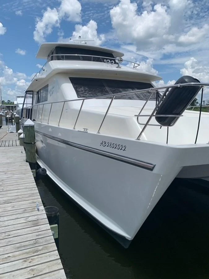 A sleek white yacht is docked at a marina under a bright blue sky with scattered clouds. aboard THE CAT FROM THE HAT Yacht for Sale
