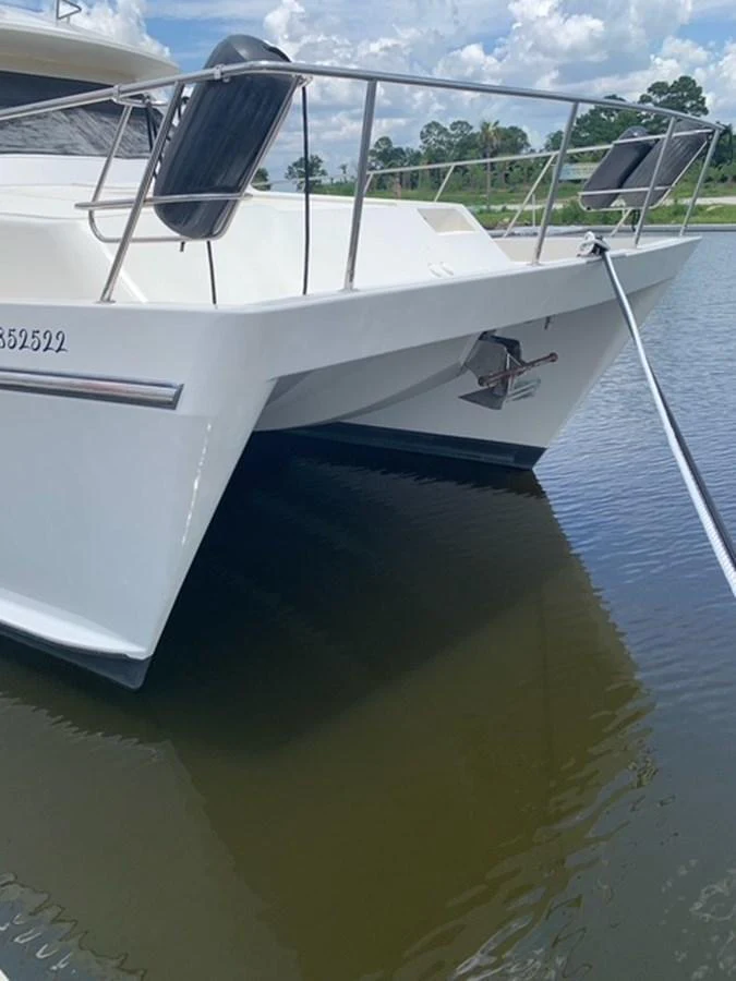 The yacht is moored in calm waters, showcasing its sleek bow design. aboard THE CAT FROM THE HAT Yacht for Sale