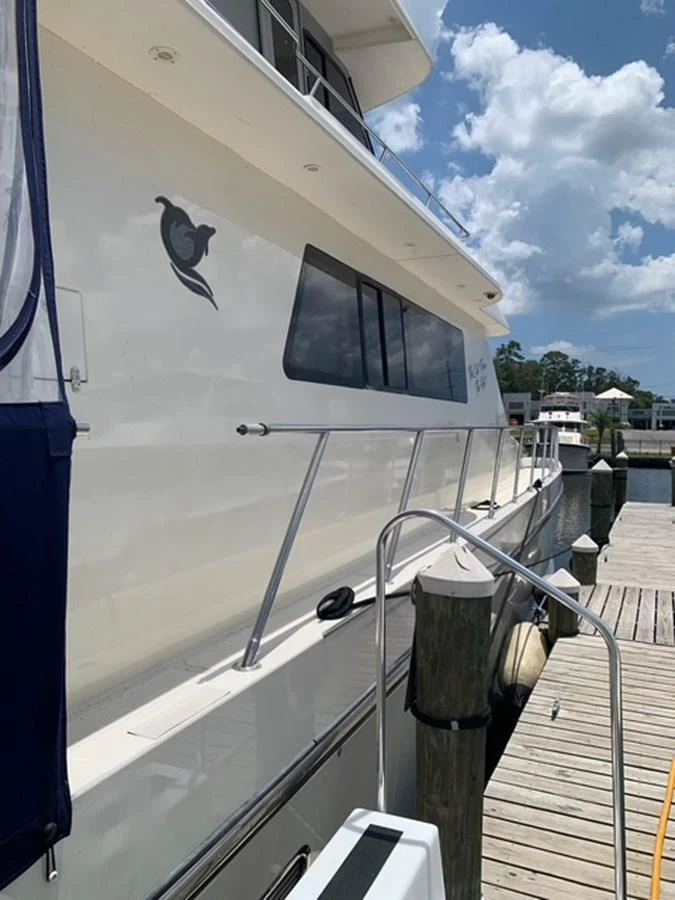 The yacht is docked at a marina, showcasing its sleek exterior and clean lines. aboard THE CAT FROM THE HAT Yacht for Sale