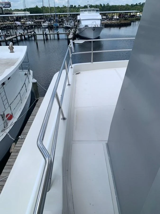 The yacht's exterior walkway offers a view of the marina and nearby vessels. aboard THE CAT FROM THE HAT Yacht for Sale
