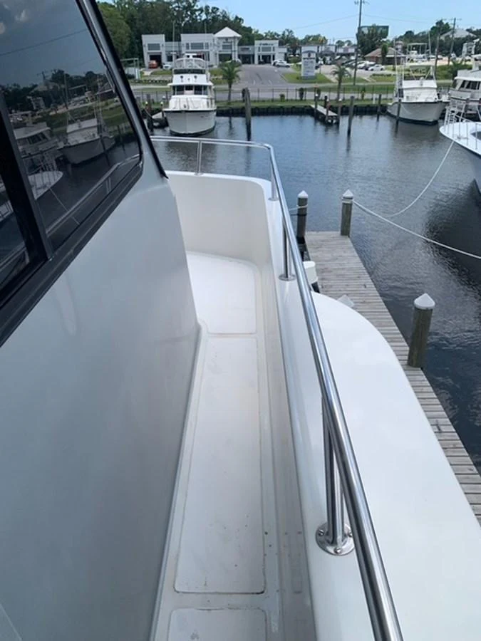 The side deck offers a secure walkway with stainless steel railings and a view of the marina. aboard THE CAT FROM THE HAT Yacht for Sale