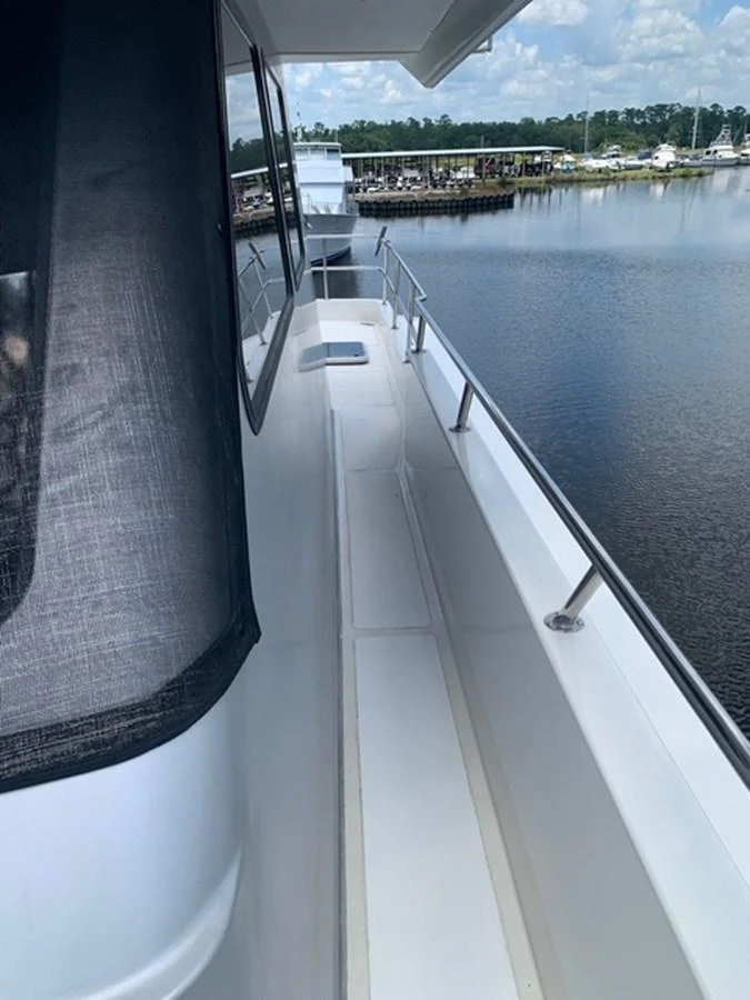 The yacht's side deck offers a sleek walkway with stainless steel railings and a view of the marina. aboard THE CAT FROM THE HAT Yacht for Sale