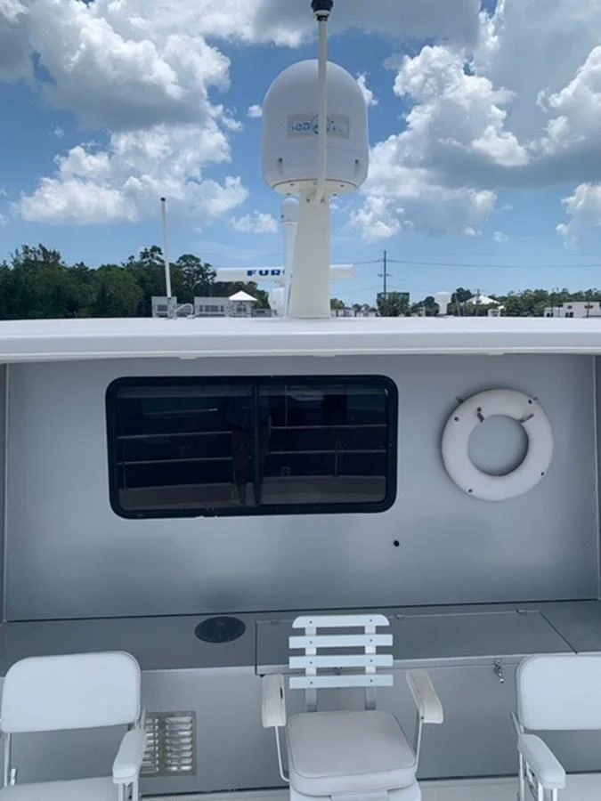 The yacht's exterior features a clean and functional design with seating and safety equipment. aboard THE CAT FROM THE HAT Yacht for Sale