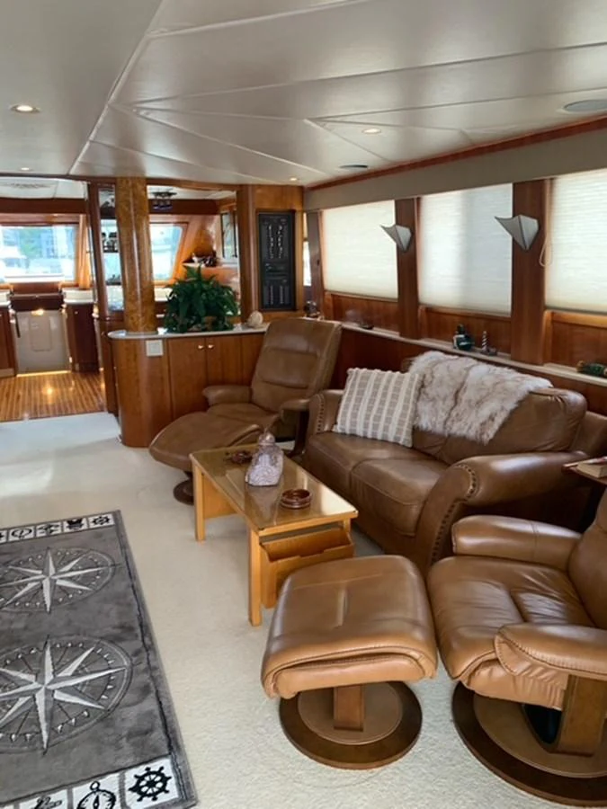 The salon features plush leather seating and elegant wooden accents, creating a cozy and inviting atmosphere. aboard THE CAT FROM THE HAT Yacht for Sale