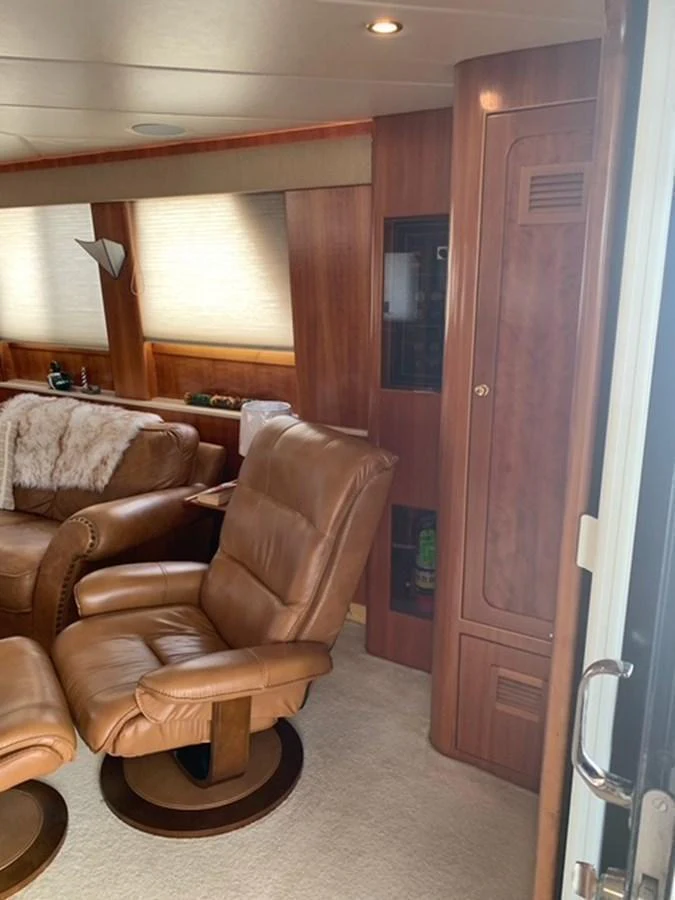 The yacht's interior features comfortable leather seating and warm wooden finishes, creating a cozy and inviting atmosphere. aboard THE CAT FROM THE HAT Yacht for Sale