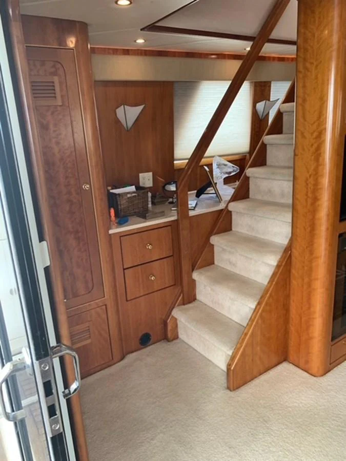 The image showcases a well-maintained interior staircase with wooden finishes and carpeted steps. aboard THE CAT FROM THE HAT Yacht for Sale