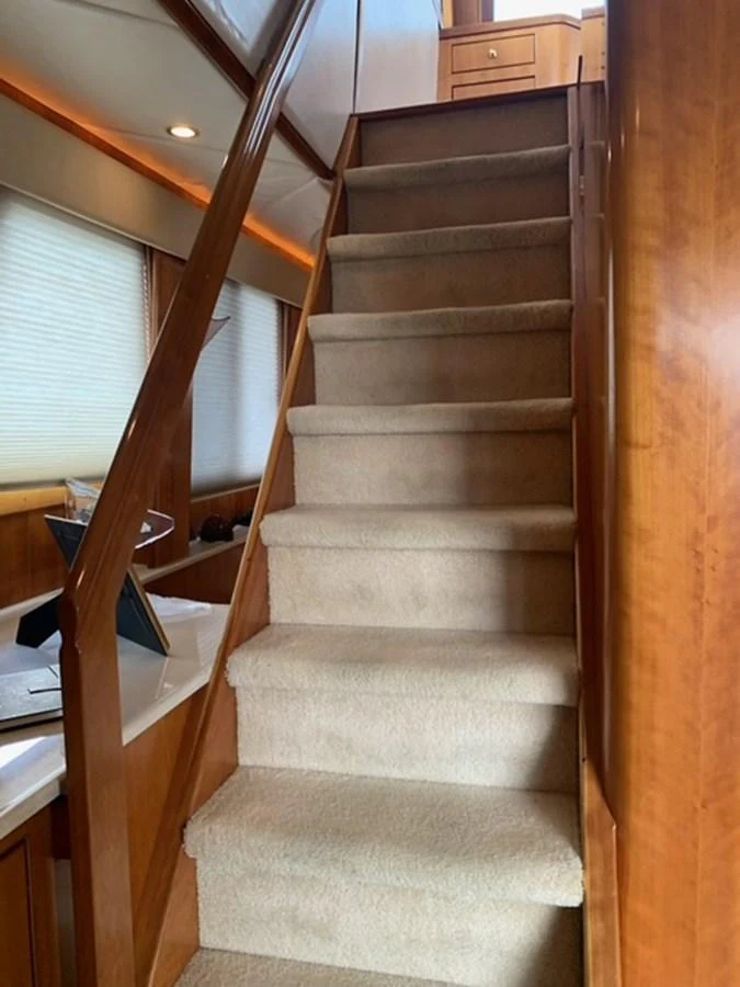 A cozy interior staircase with carpeted steps and wooden railings leads to the upper deck. aboard THE CAT FROM THE HAT Yacht for Sale