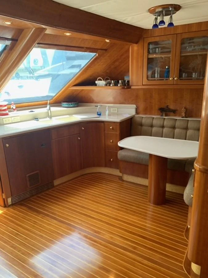 The galley features warm wood finishes, a cozy dining nook, and ample natural light. aboard THE CAT FROM THE HAT Yacht for Sale